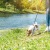 a dog on a leash on a leash by a river
